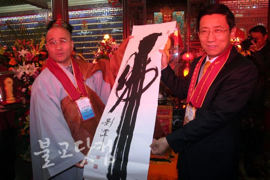 영담 스님이 주견영 중국 국가종교사무국 부국장에게 친필 작품을 선물하고 있다.