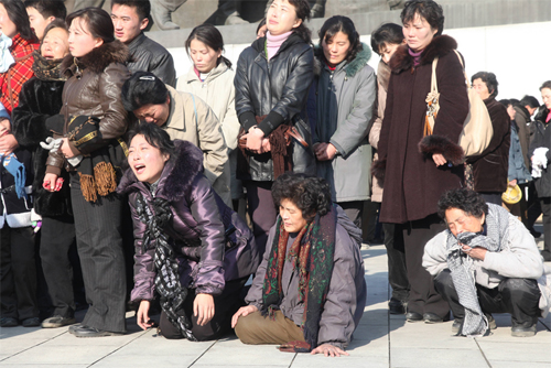 [신화=평양] 19일 김정일 사망 보도를 접한 북한주민들이 평양 만수대 김일성 주석 동상 앞에서 김정일 사망을 애도하고 있다.