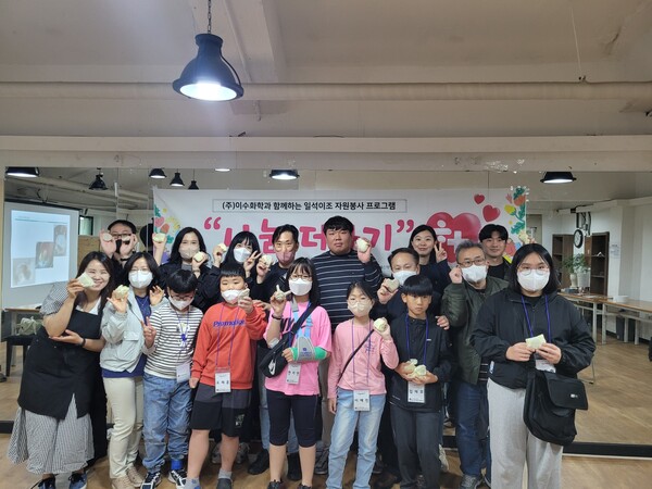 지난 13일 친환경 고체샴푸 만들기에 참여한 ㈜이수화학 임직원 자원봉사자들과 아동들이 기념촬영을 하고 있다.사진제공 울산남구종합사회복지관